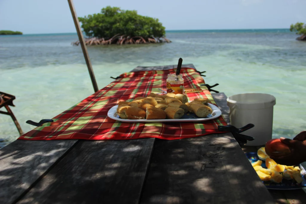 table en bois dans la mer avec apéritif créole guadeloupéen