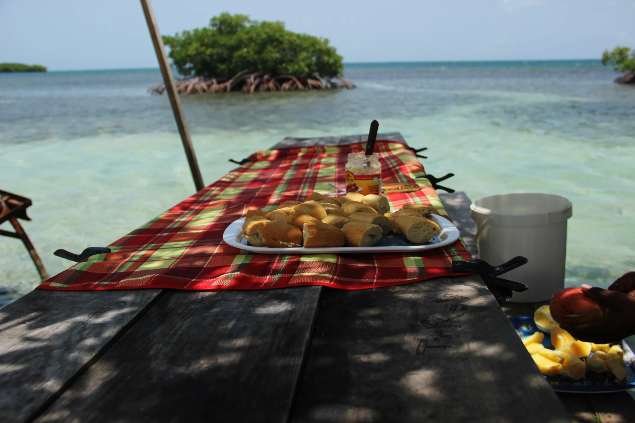 table en bois dans la mer avec apéritif créole guadeloupéen