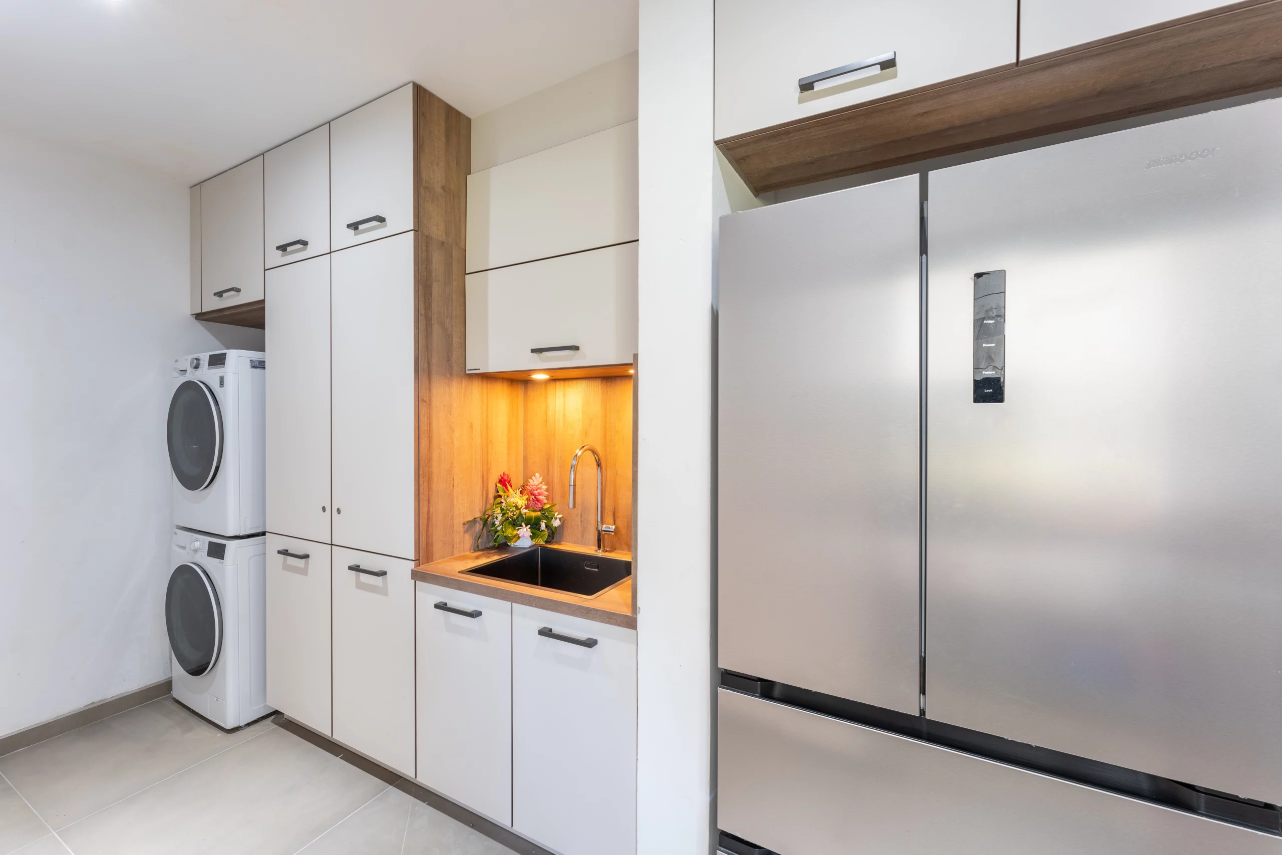 arrière cuisine et buandrie avec lave linge sèche linge et large frigo congélateur