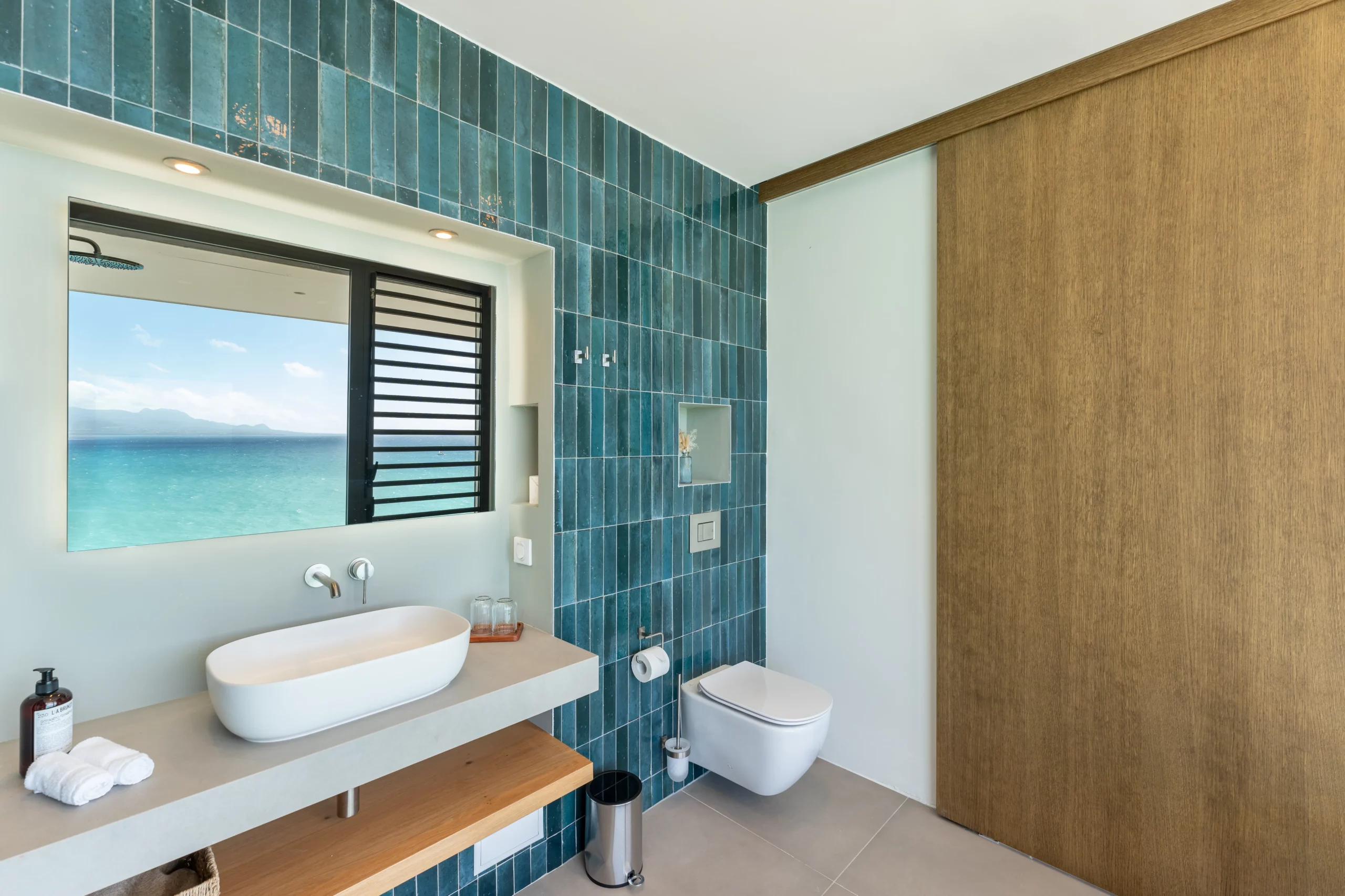 salle de bain avec faïence bleue et vue sur la mer turquoise en guadeloupe