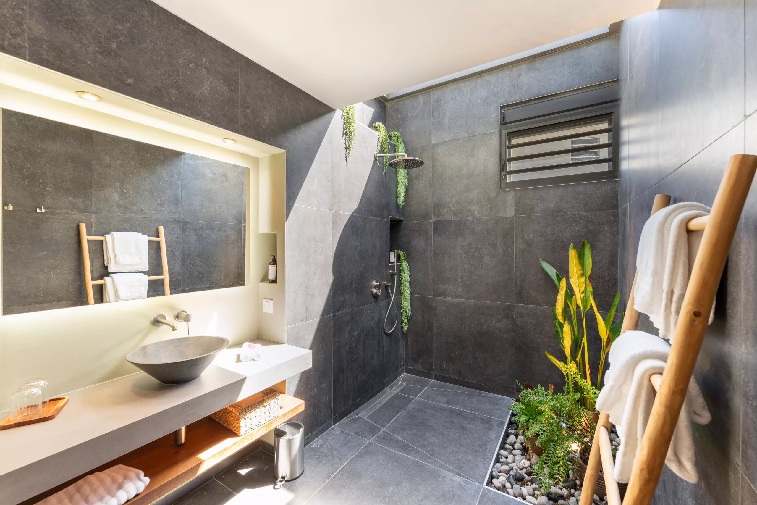 grande salle de bain avec patio tropical et carrelage noir dans la villa guacana guadeloupe
