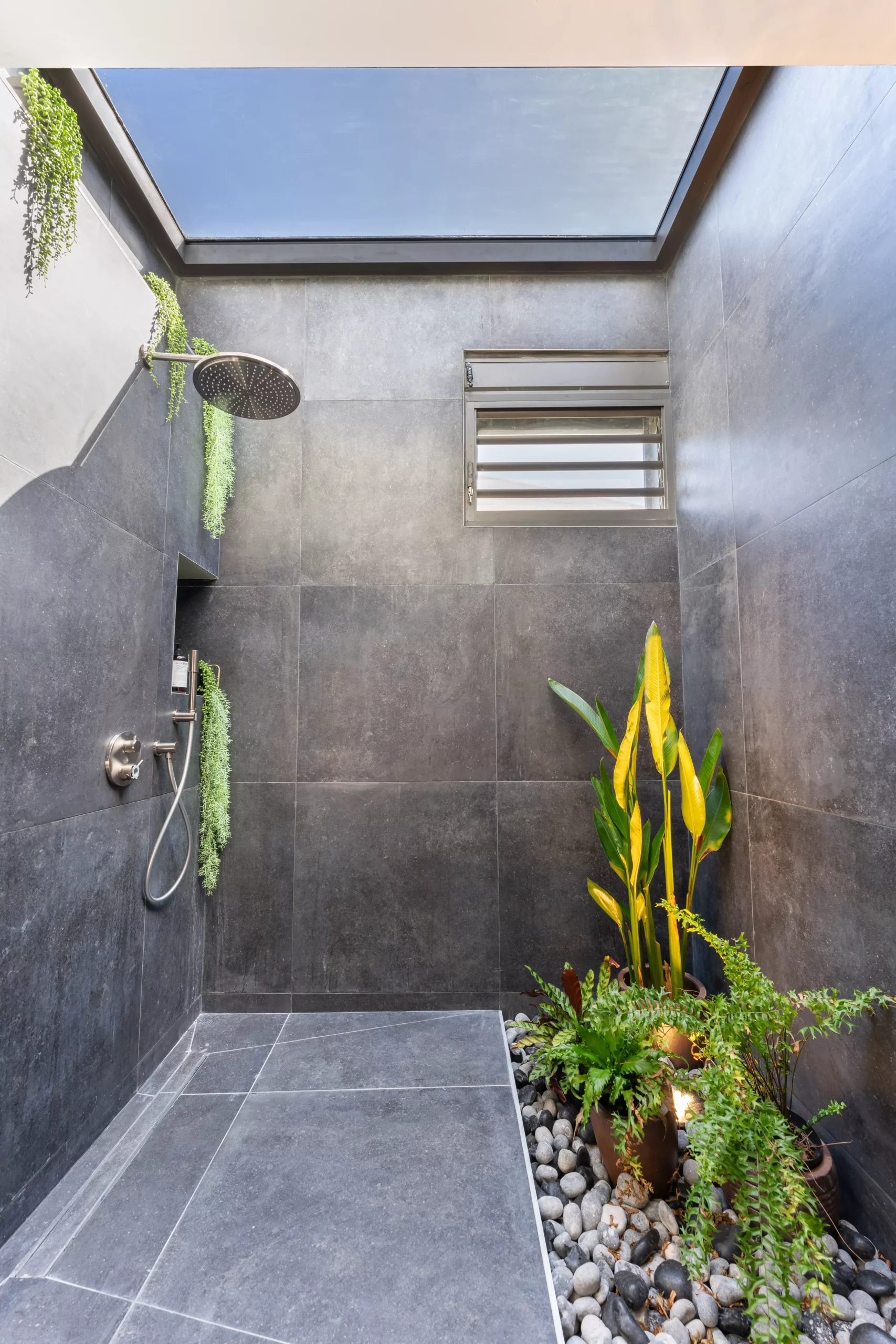 douche italienne avec verrière vue ciel et patio tropical intérieur dans une villa d'architecte en guadeloupe